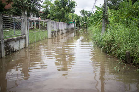 Chiangmai, Thailand -  Auguest 5 2020:  Flooding on the  asphalt  road from monsoon depression. Photo on urban fringe of chiangmai city.のeditorial素材