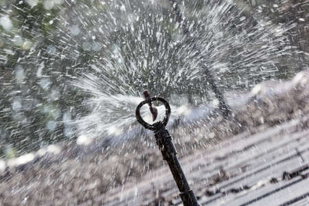 Close up of water sprinkler working on brown roofの写真素材