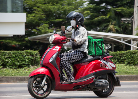 Chiangmai, Thailand - April  21 2022: Delivery service man ride a Motercycle of Grab Food. On road no.1001, 8 km from Chiangmai city.のeditorial素材