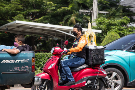 Chiangmai, Thailand - April  22 2022: Delivery service man ride a Motercycle of 7-11. On road no.1001, 8 km from Chiangmai city.のeditorial素材