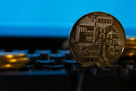 The bitcoin is placed on the keyboard with a stock graph background.の写真素材