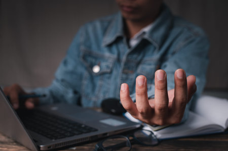 A man working on a laptop and held his other hand as though he were carrying something. concept working at home , concept working  in office.の写真素材