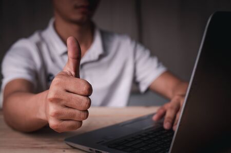 A man sat and worked and displayed a thumb, a wonderful symbol, working at home concept, working concept in office.の写真素材