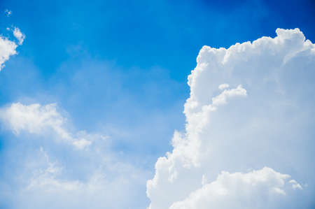 Bright sky in the daytime with white clouds and sunlight shining down.の写真素材