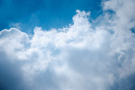 Bright sky in the daytime with white clouds and sunlight shining down.の写真素材