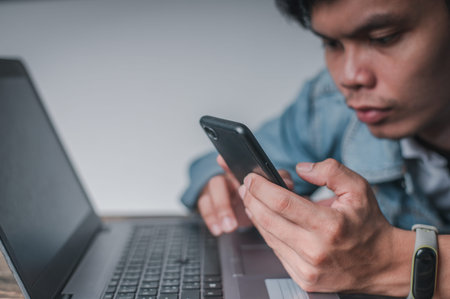 Men use their smartphones while resting from work, tired from work. Relax in front of the notebook...