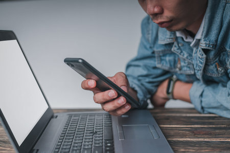 Men use their smartphones while resting from work, tired from work. Relax in front of the notebook...