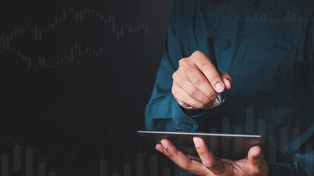 A businessman hand holding a black pen and pencil showing gesture writing on a black background...