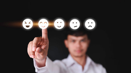 Businessman pressing feeling icon on face from a virtual screen. Ideas about satisfaction and opinions. Technology effects.の写真素材
