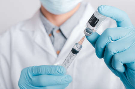 Doctors wear a surgical mask and glasses, Scientists, Scientists hold syringes and vaccines for COVID-19., vaccination and laboratory experiments. Virus protection concept COVID-19,の写真素材