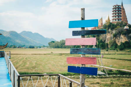Road signs multicolored old wooden arrows on nature and mountain background.の写真素材