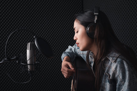 Asian female singer with a passion for music and microphone. While playing her guitar in a...