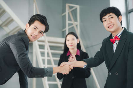 Business man in a suit shakes hands to agree a business partnership agreement. Business etiquette concept of congratulation, concept of handshake during office meeting.の写真素材