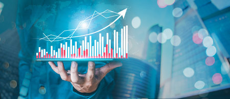 Business man are using a tablet computer to work on graphs, financial data, with a growing...