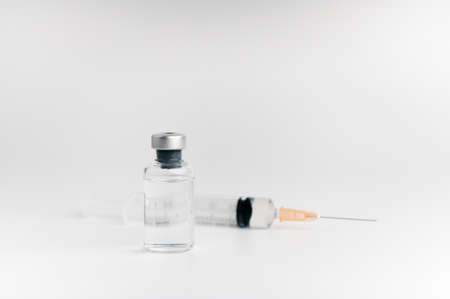 The vaccine vials, syringes and stethoscope are placed together on a white background. COVID-19 virus protection concept, vaccine invention and production concept.の写真素材