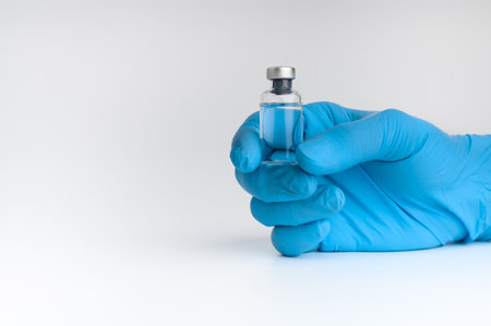 Doctors wear masks and glasses, scientists hold syringes and vaccines. Vaccination and laboratory experiments, COVID-19 virus protection concept, vaccine invention and production concept.の写真素材