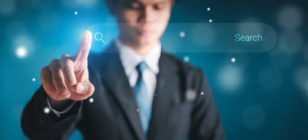 Businessman touch the search button on the virtual screen to find strategy ideas internet technology information network for business with dark background.の写真素材