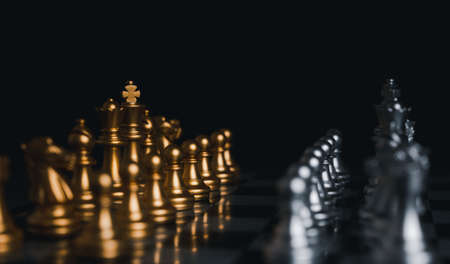 Gold and Silver king winner surrounded with silver chess pieces on chess board game competition.concept strategy, leadership and success business.の写真素材