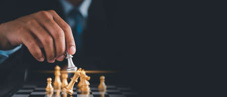 Businessman moves chess with hand.Strategic planning concept about mistakes topple the opposing team and analyze the development for the success of the organization.の写真素材