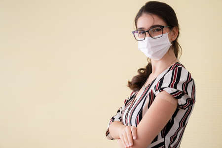 Young women wearing masks standing show plaster bandage at the shoulder.の写真素材