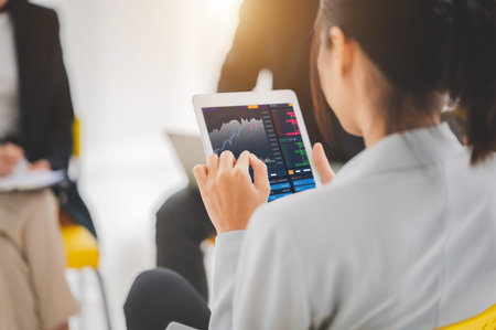 Young money businessman sitting staring at a computer screen displaying a cryptocurrency featuring...