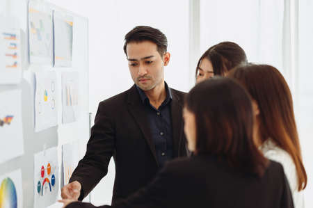 Businessman or manager presents a discussion graph, a strategic planning report, and discusses ways to increase profits with colleagues at the workshop. Brainstorming and teamwork concept.の写真素材