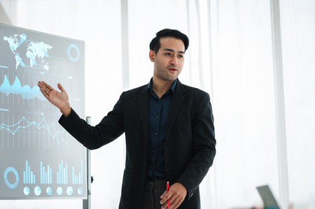 Businessman or manager presents a discussion graph, a strategic planning report, and discusses ways to increase profits with colleagues at the workshop. Brainstorming and teamwork concept.の写真素材