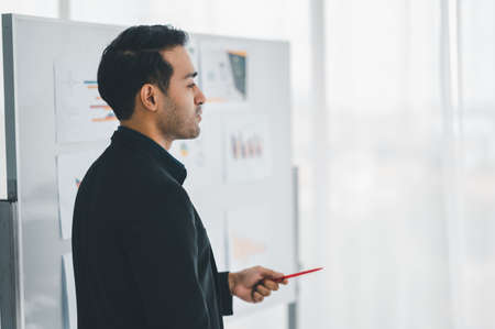 Businessman or manager presents a discussion graph, a strategic planning report, and discusses ways to increase profits with colleagues at the workshop. Brainstorming and teamwork concept.の写真素材