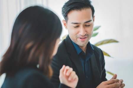 Asian business hold a small meeting inside the office or conference room. Brainstorm to exchange ideas. There are stock boards Laptops and tablets are communication tools. Unity teamwork concept.の写真素材
