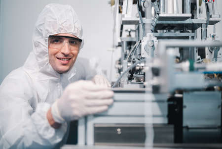 Scientists wearing protective clothing Inspect mask making machines in a laboratory at an industrial plant. Anti-virus production warehouse. concept of safety and prevention coronavirus covid-19.の写真素材