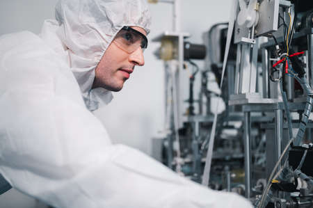Scientists wearing protective clothing Inspect mask making machines in a laboratory at an industrial plant. Anti-virus production warehouse. concept of safety and prevention coronavirus covid-19.の写真素材