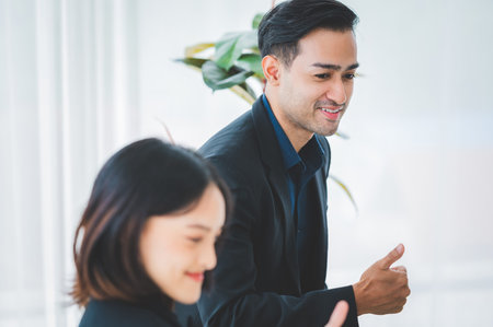Asian business hold a small meeting inside the office or conference room. Brainstorm to exchange ideas. There are stock boards Laptops and tablets are communication tools. Unity teamwork concept.の写真素材