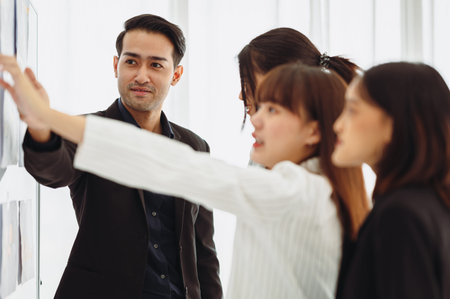 Businessman or manager presents a discussion graph, a strategic planning report, and discusses ways to increase profits with colleagues at the workshop. Brainstorming and teamwork concept.の写真素材