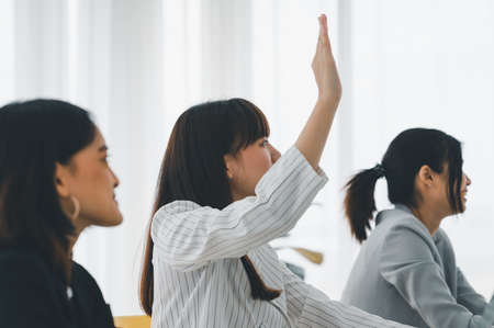Business raises his hand to raise questions about the meeting content with the presenter in the workshop. Brainstorming and teamwork concept.の写真素材