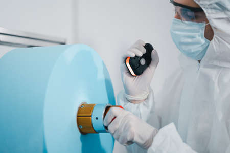 Scientists wearing uniform protection. Check the manufacturing process of face masks. In a laboratory at industry plants. The concept for security and protection coronavirus covid-19.の写真素材