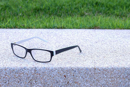 Glesses on blurred cement and grass backgroundの写真素材