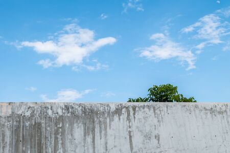 Dirty concrete wall with beautiful blue sky at the midday backgroundの写真素材