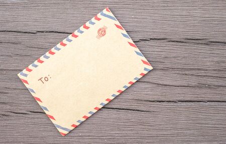 Closeup brown envelope on old wooden table textured  backgroundの写真素材