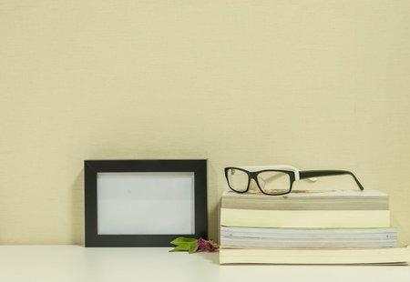 Frame for a photo with glasses on books background