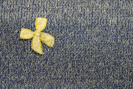 Gold ribbon on black fabric texture backgroundの写真素材