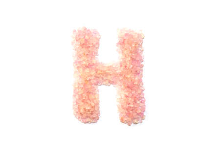 Closeup pile of pink crystal stone in H english alphabet isolated on white backgroundの写真素材