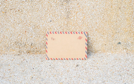 Closeup brown envelope on blurred stone floor and wall textured background