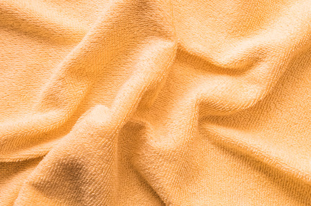 Closeup wrinkled orange napkin fabric backgroundの写真素材