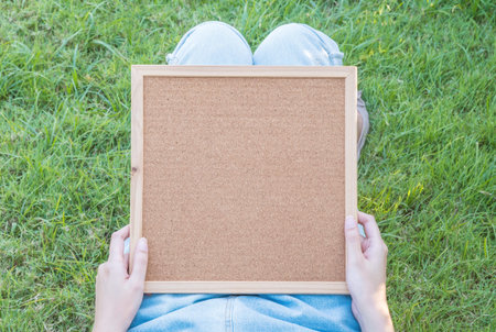 Closeup cork board on body of woman lied on grass floor