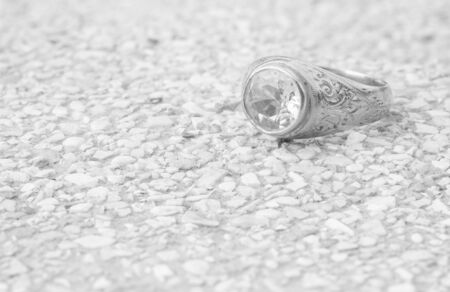 Closeup old diamond ring on blurred stone floor background in black and white toneの写真素材