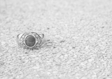 Closeup old jade ring on blurred stone floor background in black and white toneの写真素材