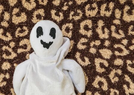 cute ghost doll on brown fabric backgroundの写真素材
