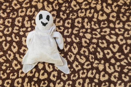 cute ghost doll on brown fabric backgroundの写真素材