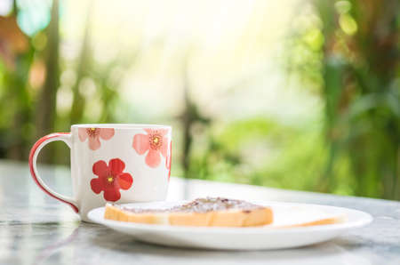 Closeup cute cup on blurred marble desk and garden view in the morning textured backgroundの写真素材