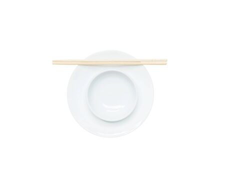 Closeup white ceramic chalice on circle dish wood chopsticks isolated on white backgroundの写真素材